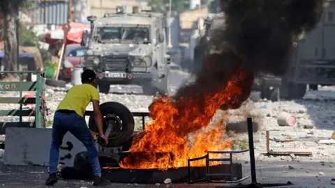 Getty Images Palestinian burns tyre in Nablus (file photo)