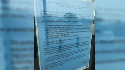 A blue letter saying that Vue Entertainment Ltd has applied for a Premises Licence from Swindon Borough Council. It is hung up in the window of the former Empire cinema in Swindon.