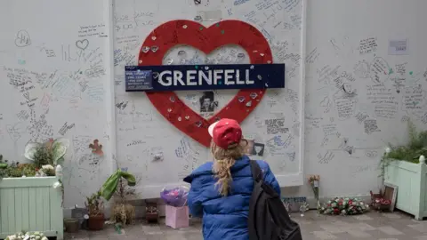 Anselm Ebulue/Getty Images A mourner pays respects on the third anniversary of the Grenfell tower fire