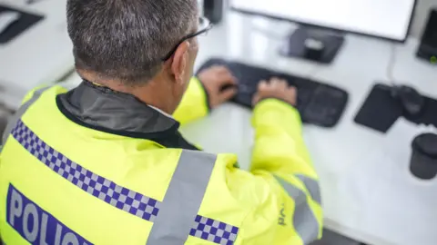 Getty Images Police officer searching on computer