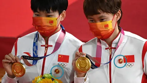 Getty Images Bao Shanju and Zhong Tianshi receive gold medals at the Olympics