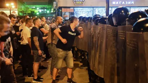 Getty Images Crowds confront police in Minsk, 9 Aug 20