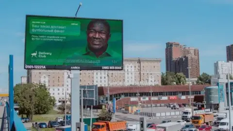 Delivery Club Poster which says "Your order will be delivered by a football fan. He loves Bollywood movies and Russian music"