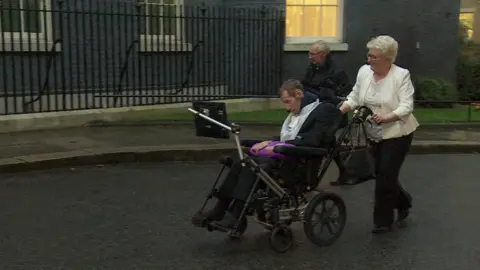 Row Burrow in Downing Street with parents Irene and Geoff