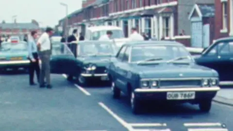 Police officers around getaway car