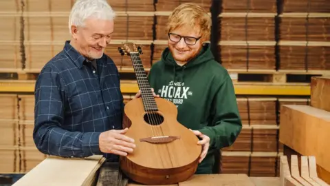 PA Media Ed Sheeran with guitar maker George Lowden and the guitar he is donating