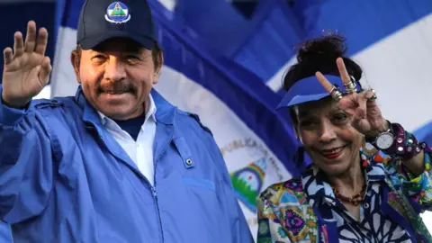 AFP/Getty Images Nicaraguan President Daniel Ortega with his wife, Vice-President Rosario Murillo, gesture at supporters during a rally in Managua, 5 September 2018