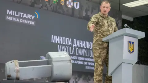Reuters Ukrainian military official Mykola Danyliuk points at a briefing in Kyiv to what he says is a dud warhead of Russia's X-55 cruise missile found in western Ukraine. Photo: 1 December 2022