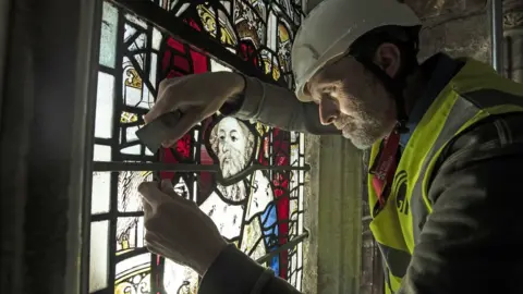 Danny Lawson/PA Conservation Manager Nick Teed removes a stained glass window during the first phase of work to protect 600-year-old stained glass windows