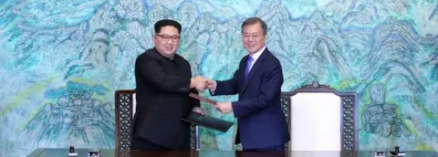 Getty Images Kim Jong-un and Moon Jae-in shake hands (30 April 2018)
