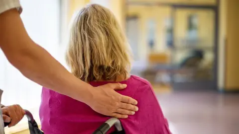 Getty Images Carer pushing wheelchair