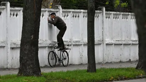 Sergei Supinsky/AFP A man looks through a hole in a wall after a building was destroyed in Bila Tserkva, in Ukraine