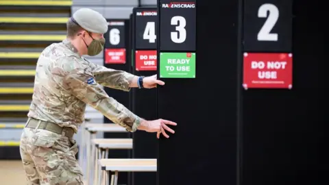 PA Media Members of the Royal Scots Dragoon Guard help set up a vaccination centre at the Ravenscraig Regional Sports Facility