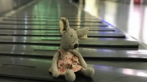 Stansted Airport Mouse toy on luggage carousel