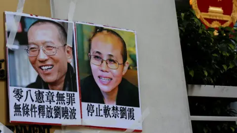 Reuters Photos of Chinese Nobel rights activist Liu Xiaobo (L) and wife Liu Xia are left by protesters outside China"s Liaison Office in Hong Kong, China June 27, 2017