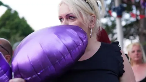 PA Media Hollie Dance holding a purple balloon