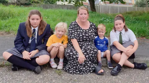 Jodie and family sitting on a concrete kerb