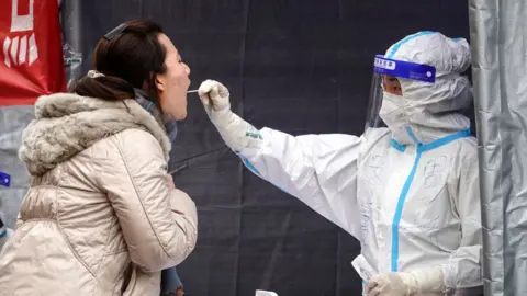 Getty Images A resident undergoes a nucleic acid test for the Covid-19 coronavirus in Xi'an in China's northern Shaanxi province