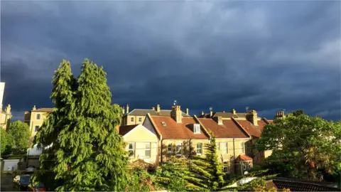 Getty Images Clouds gather over homes
