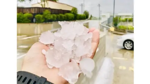 Reuters A person holds up a handful of large hailstones in Gympie, Queensland