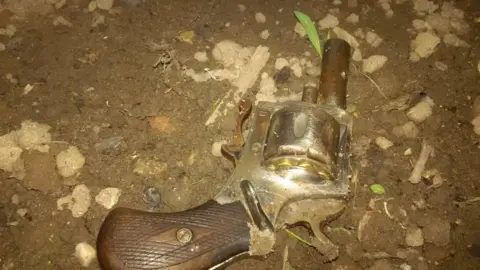 Nottinghamshire Police A gun on soil after being thrown into a garden.