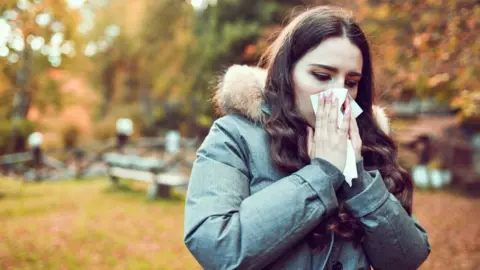 Getty Images Woman outdoors blowing her nose