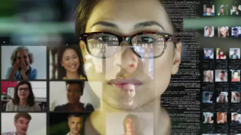 Getty Images Woman's face reflected in a video conference screen showing several other faces