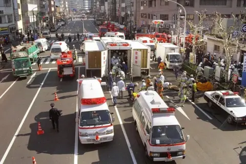 Getty Images Rescue workers carry the survivors to the emergency rescue tents at Tokyo Metro Tsukiji Station on March 20, 1995 in Tokyo.
