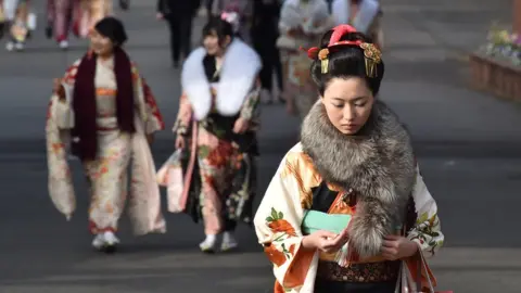 Getty Images Twenty-year-old women wearing kimonos leave after attending a 'Coming-of-Age Day' celebration