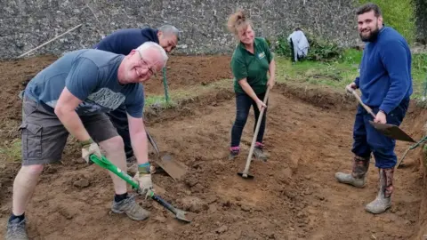 BBC/Jadzia Samuel Members from Communigrow dig a hole at the site in East Malling