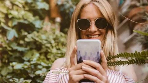 Getty Images A woman on her phone