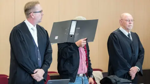 AFP/Getty Defendant Ralf S is flanked by his lawyers Olaf Heuvens (L) and Gerhard Hauptmanns (R) at the district court of Düsseldorf, western Germany, on July 31, 2018,