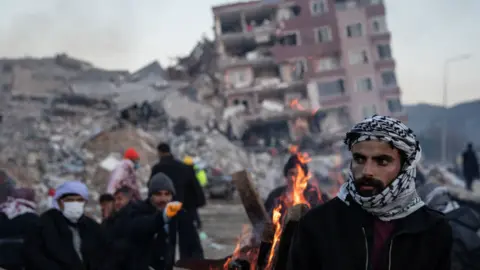 Getty Images People wait for news of their loved ones, believed to be trapped under collapsed buildings on February 09, 2023 in Hatay, Turkey