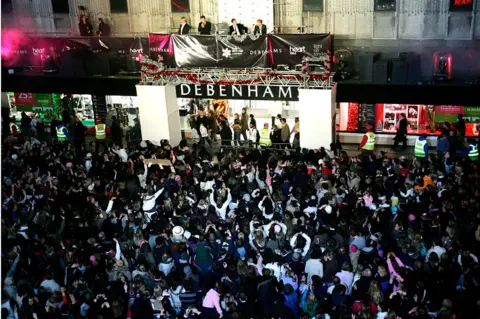 Getty Images Westlife perform to a crowd outside of a Debenhams store