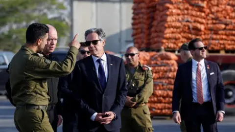 Reuters U.S. Secretary of State Antony Blinken walks with Israeli Defense Minister Yoav Gallant, at the Kerem Shalom border crossing, Israel