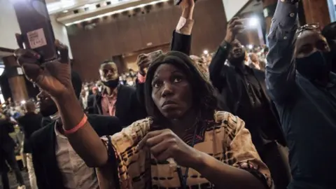 Journalists and supporters of the presidential party record the installation of the temporary board of the Parliament of the Democratic Republic of Congo, in Kinshasa on December 8, 2020