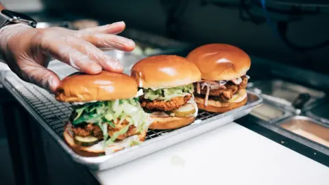 Mason Adams Three Sam's Crispy Chicken burgers