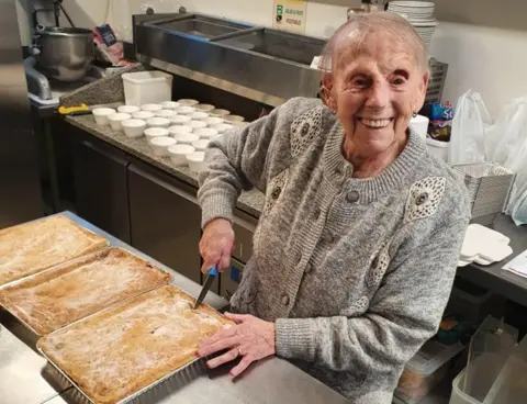 Les Nicoll Flo Osborne cutting up the pies she had made for the elderly and vulnerable