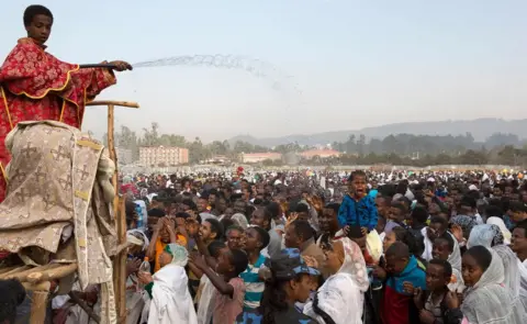AFP A clergy boy sprays blessed water onto patrons of the Ethiopian Orthodox church during the Timket, an Epiphany festival, in Addis Ababa, on January 19, 2018.