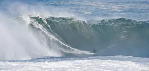 Niall Carson / PA Media Surfers riding high waves in Mullaghmore, County Sligo