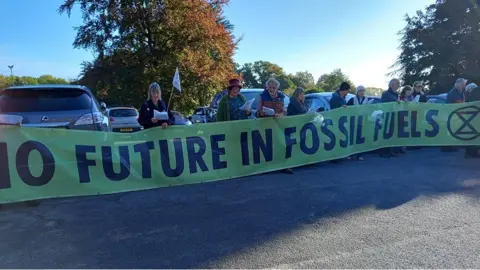 Protesters holding no fossil fuels banner