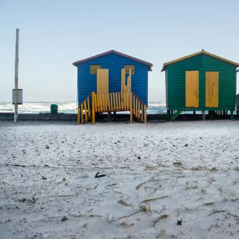 Nicky Willcock An image of beach houses next to a snow-covered beach