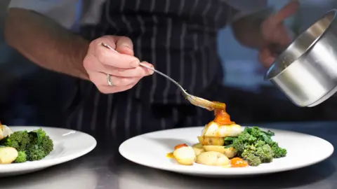 Getty Images Kitchen staff plate up food