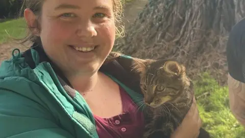 Photo of Willow the kitten with her owner Meghan Blainaut and her rescuer Mike Bailey