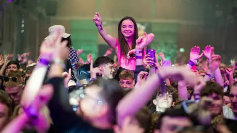 Getty Images A woman dances on someone's shoulders at the club night