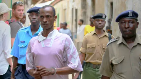 Reuters Ali Kololo, a former employee of the Kiwayu Safari Village, is escorted by police, July 2013