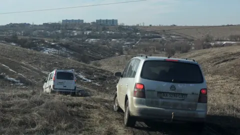 Reuters people leave kharkiv by driving acros fields