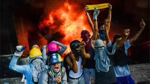 AFP A masked group of youths take part in an attack on the administration headquarters of the Supreme Court of Justice as part of protests against President Nicolas Maduro in Caracas, on June 12, 2017.