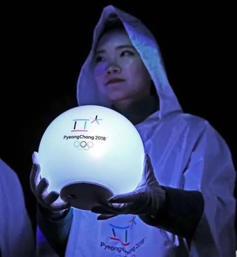Getty Images A woman holds a glowing ball with the Pyeongchang Olympics 2018 on
