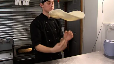 Joshua Steer tossing pizza dough